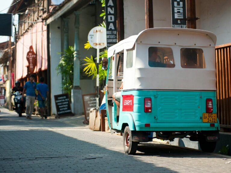 Small tuk car waits in laneway in coastal city in Sri Lanka, waiting for passengers.
