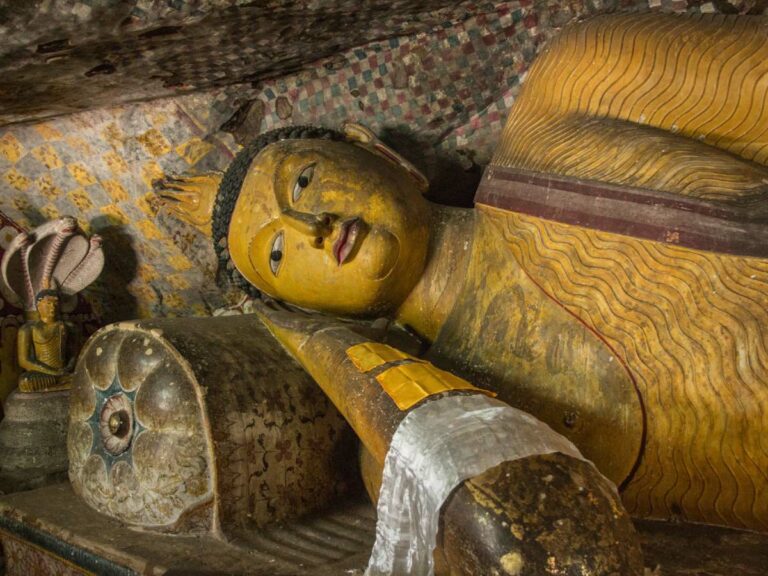 Huge statue of Buddha lying on it's side in a cave temple.