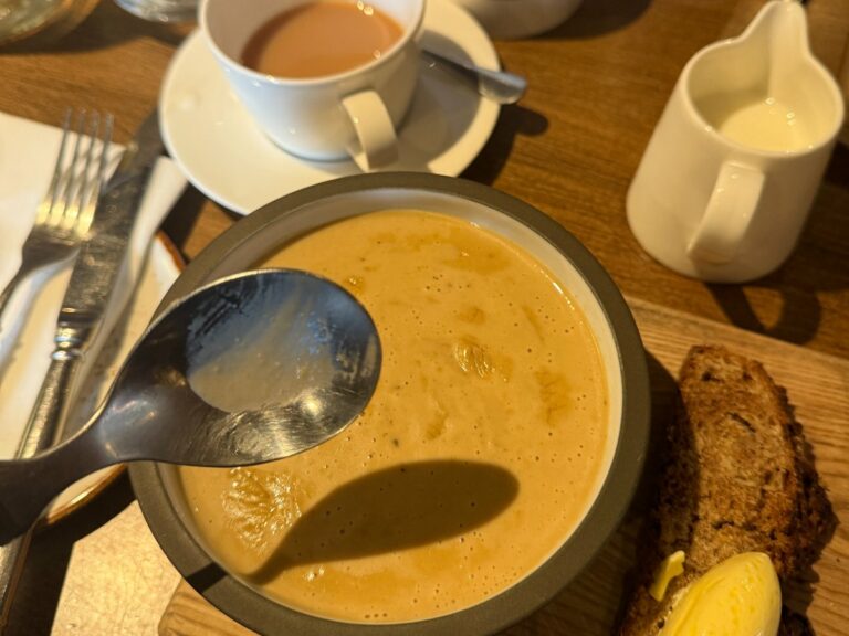 Local café dining with pumpkin soup, spiced bread and tea served on wooden table